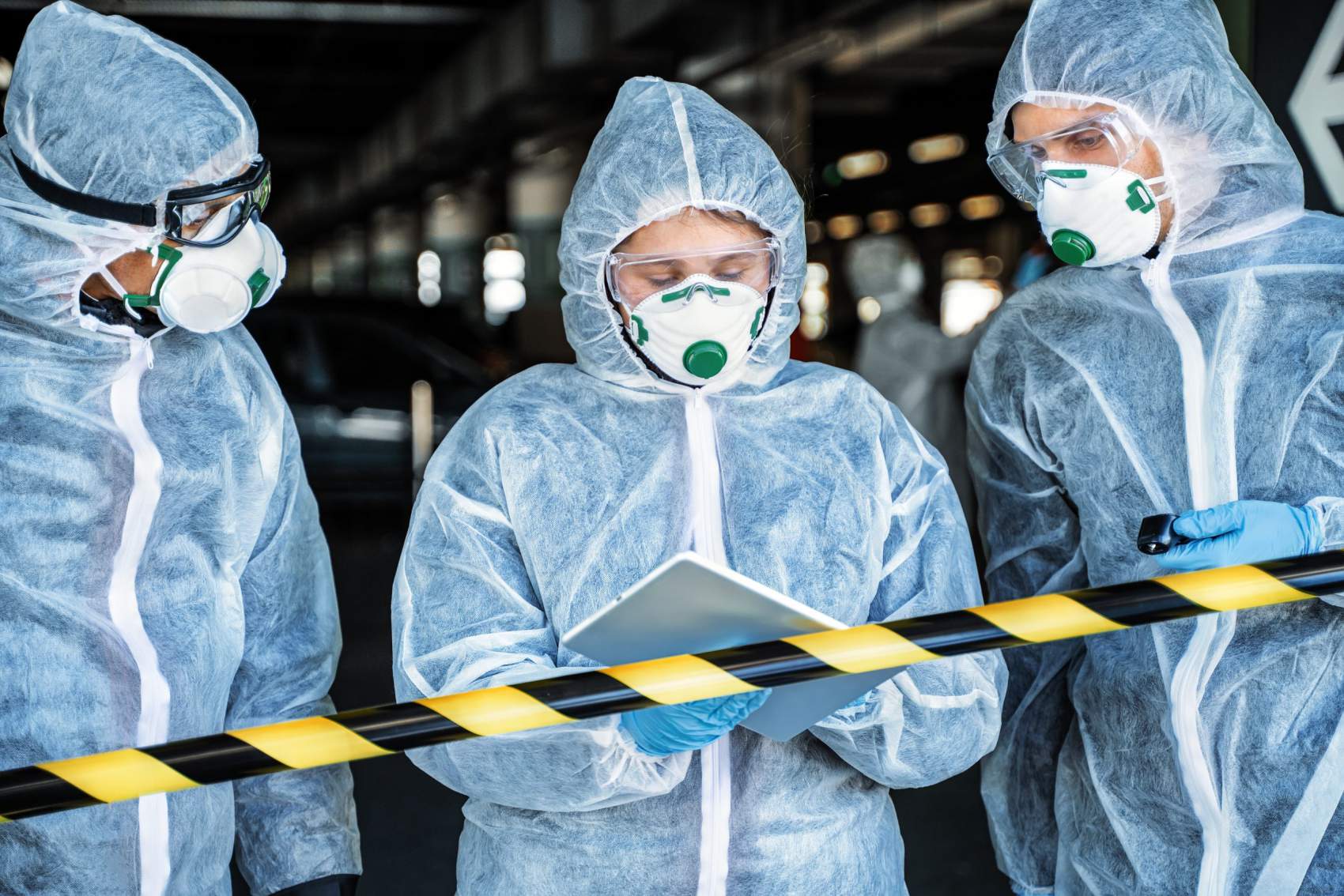 Team of healthcare workers wearing hazmat suits working together to control an outbreak in the city